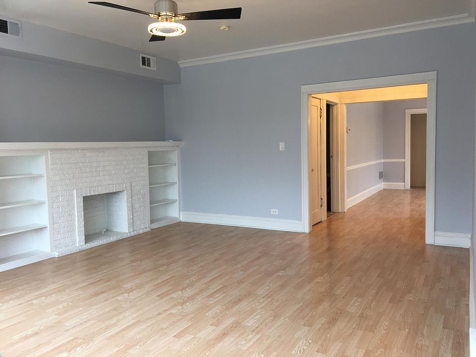 Large, bright living room filled with natural light and built in shelves.
