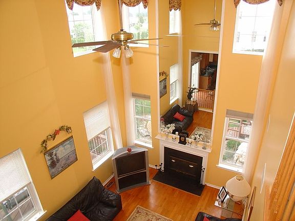 Soaring family room offers wood flooring & wood burning fireplace.