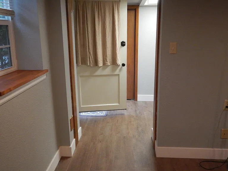 view from bedroom area into hallway and front door to outside