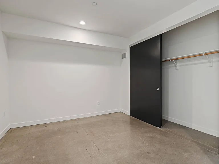 Bedroom with Closet, Recessed Lighting, and Concrete Flooring
