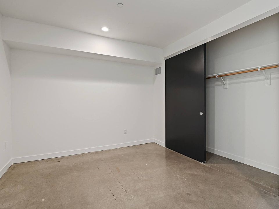 Bedroom with Closet, Recessed Lighting, and Concrete Flooring