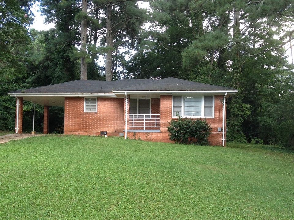 1950s cottage with lawn and carport
