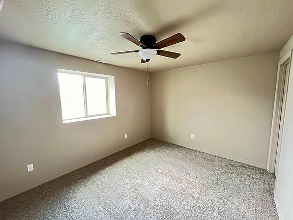 Primary bedroom with extra outlets, a ceiling fan, and walk in closet