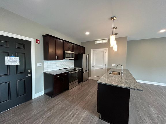 Kitchen with island. Includes dishwasher, refrigerator with ice maker, microwave, stove / oven.