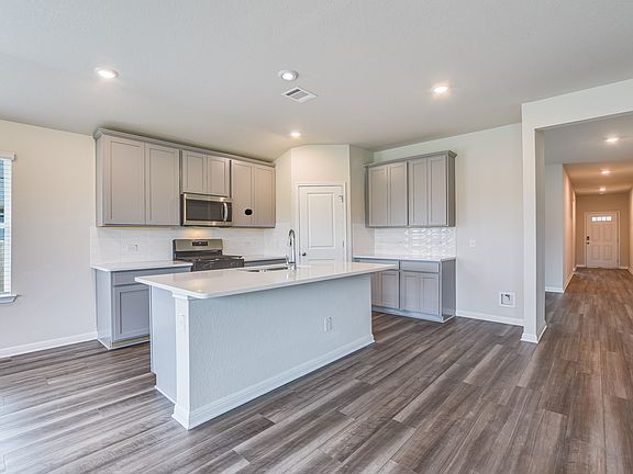 The Distinct design package features stone colored cabinets and white quartz countertops.