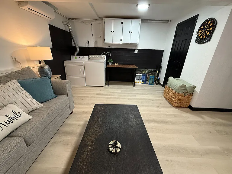 Multifunctional lounge area with comfortable seating, durable flooring, and an in-unit washer and dryer for added convenience