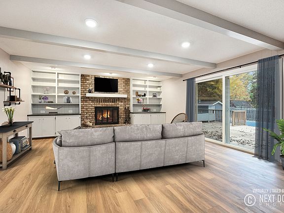 Large family room with fireplace and sliders to the deck and pool.