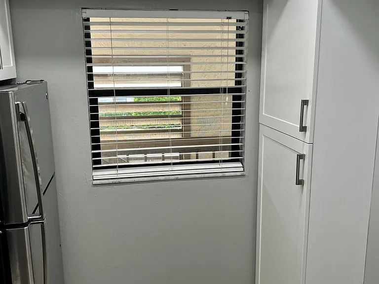 Built in kitchen pantry for storage across from refrigerator.