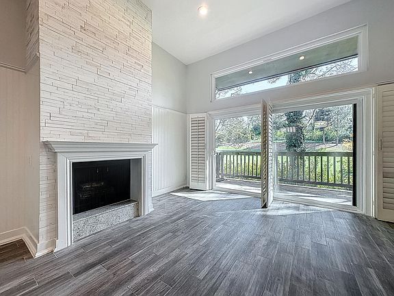 Living Room with Fireplace, large new sliding doors open to large deck on 6th Fairway Big Canyon golf course, plantation shutters, new granite on fireplace base