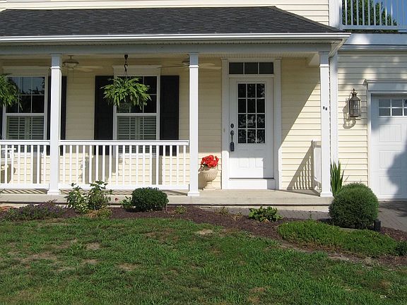 covered front porch with two fans & a porch swing