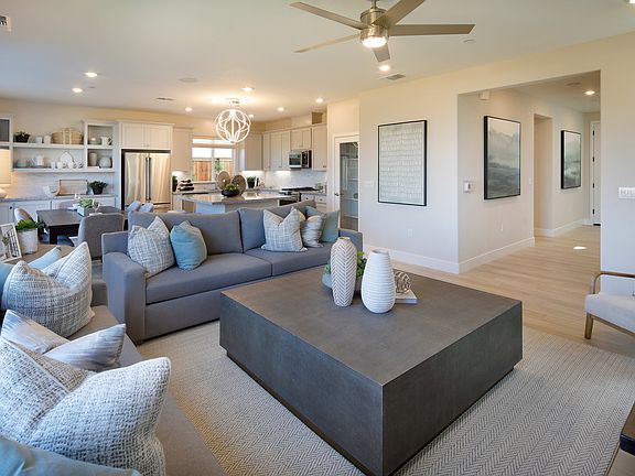 A modern and stylish living room with a gray sectional sofa, a large coffee table, and various decor