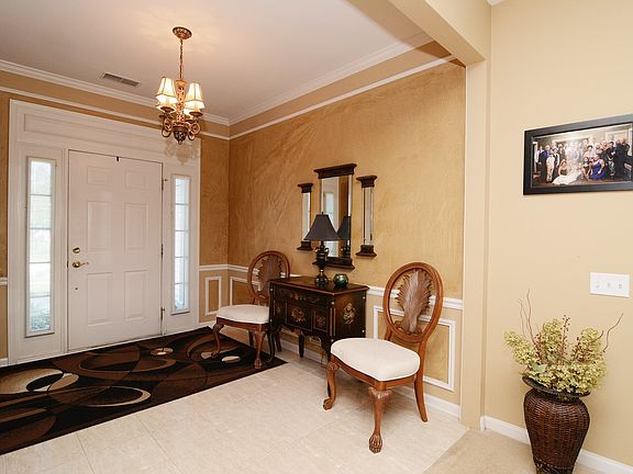 Elegant Foyer with Crown Moulding, Custom Trim and Ceramic Tile