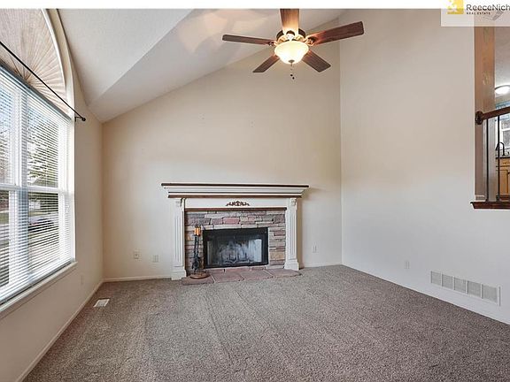 The bright formal living room features soaring ceilings and fireplace with cultured stone which makes the most beautiful focal point
