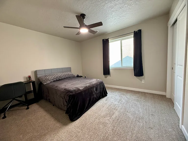 Comfortable bedroom with ceiling fan and large window. Room size about 10'11"x 12'2".