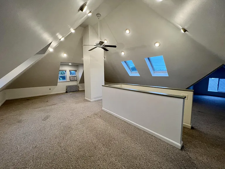 Top floor living room/mixed use space with skylights and LED lighting