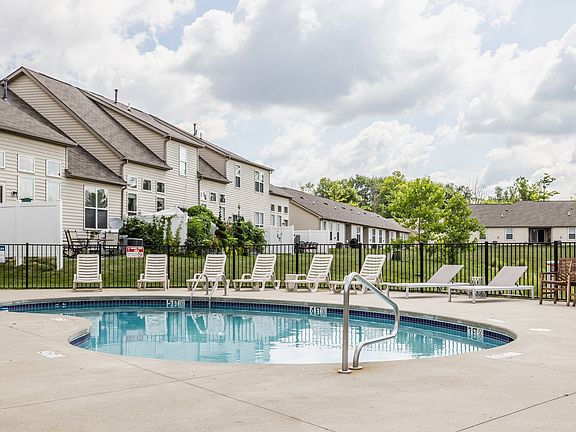 Dive into relaxation at our sparkling pool, surrounded by comfortable lounge chairs and scenic apartment views.