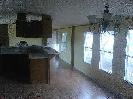 Living room kitchen- freshly painted white with laminate floors