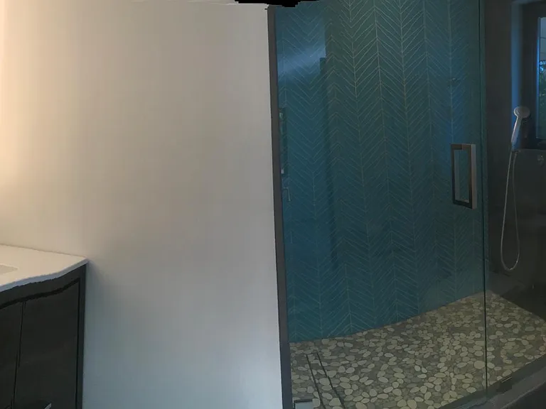 Luxurious custom bathroom with large glass tile shower & window overlooking garden.