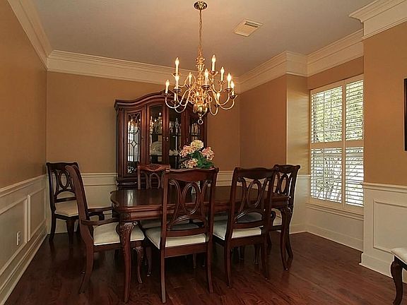Formal dining room has wainscot, hardwood floors