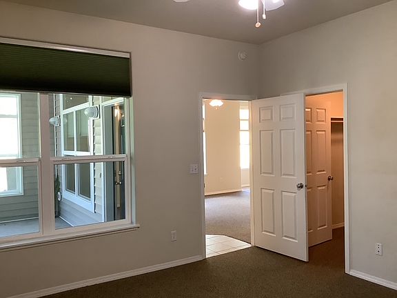 Master bedroom with walk in closet, en-suite bath, and window to porch area.