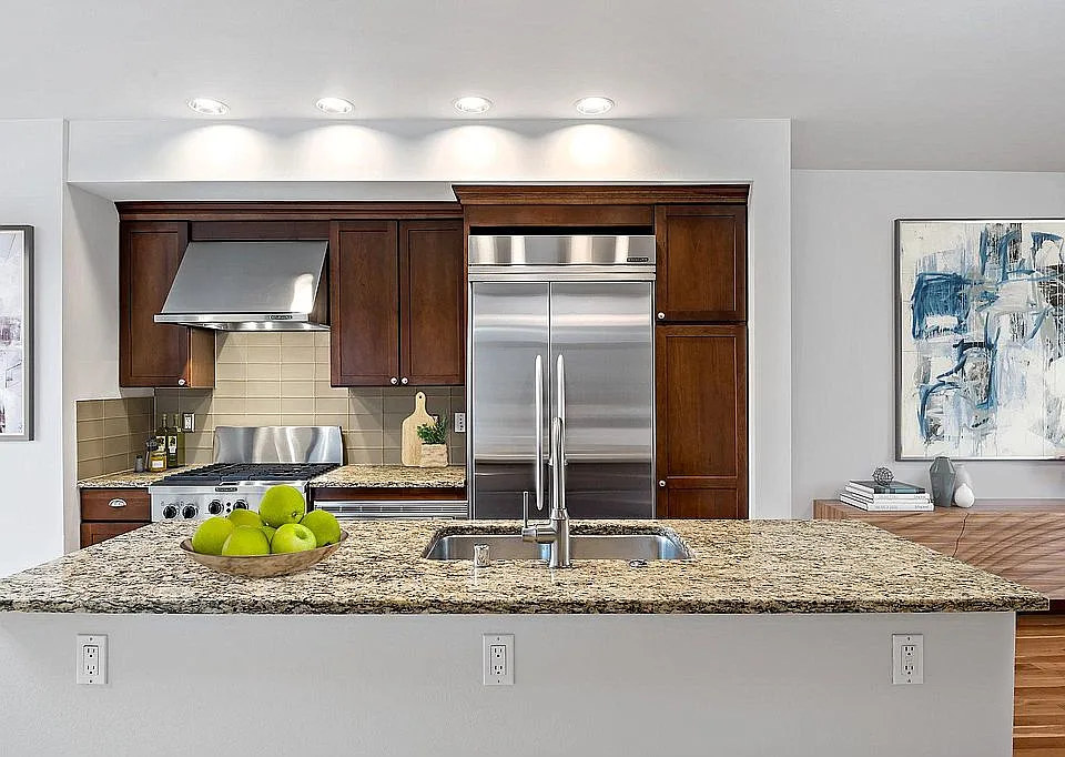 Gourmet kitchen with slab granite counters, glass tile backsplash, gas oven/range, and built-in refrigerator. Kitchen Aide appliance package. (second floor)