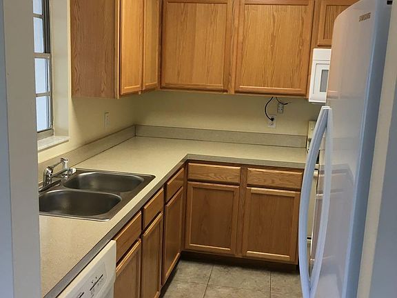 Kitchen dishwasher, stainless steel sink with disposal, large fridge with ice and water on front.