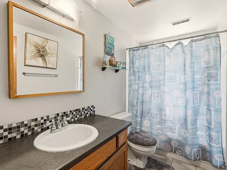 upstairs bathroom features tiled backsplash, double sinks and tiled bath/shower