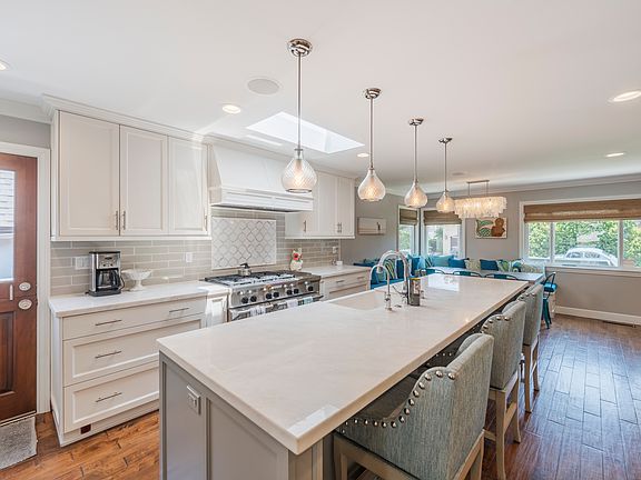 Chef kitchen with 6 burner stove plus griddle, double ovens, tons of huge drawers and cabinets and a large marble island with custom swivel chairs