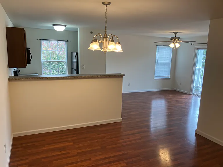 View from entry way. Master bedroom is to the left. Living room visible in the back. Dining area is front and centered.
