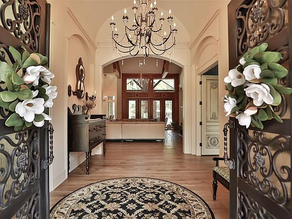 Grand entrance with wrought iron custom doors and a stunning chandelier!