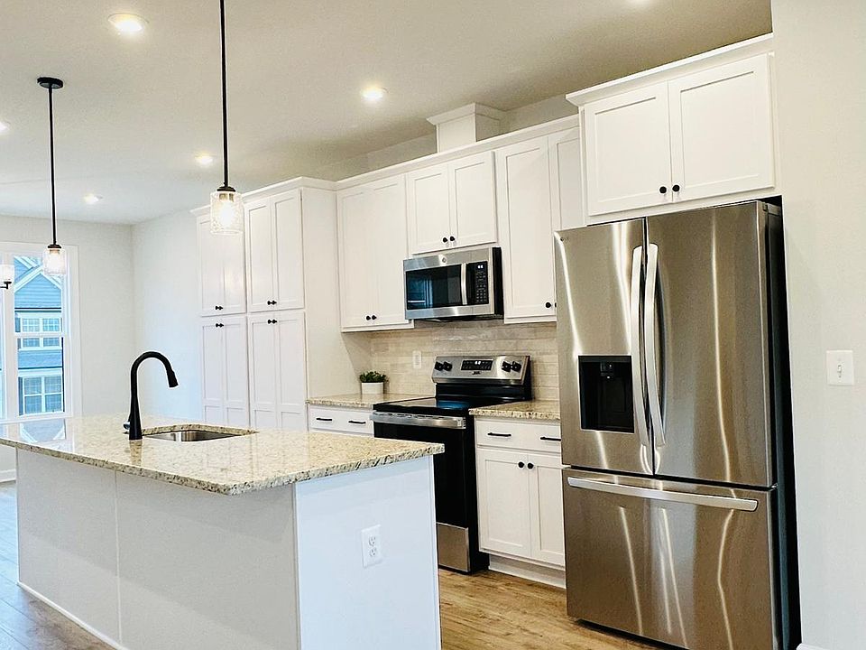 Note the oversized island, granite countertops, double pantry, stainless appliances