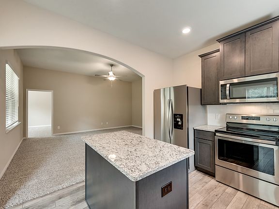 Enjoy stunning granite countertops and designer wood cabinetry in the kitchen.