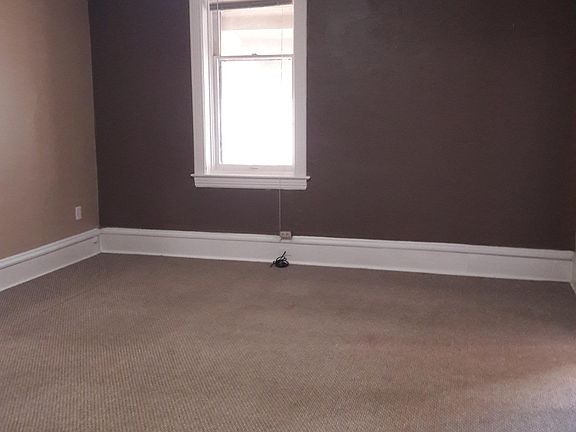 of living room from kitchen. Entry door to left. bedroom to right.