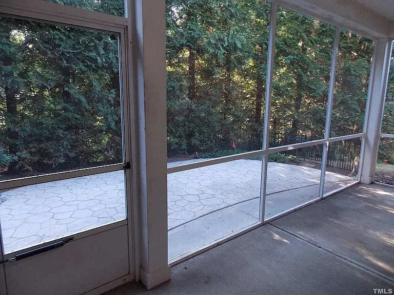 Screened-in porch with stamped concrete patio and private backyard