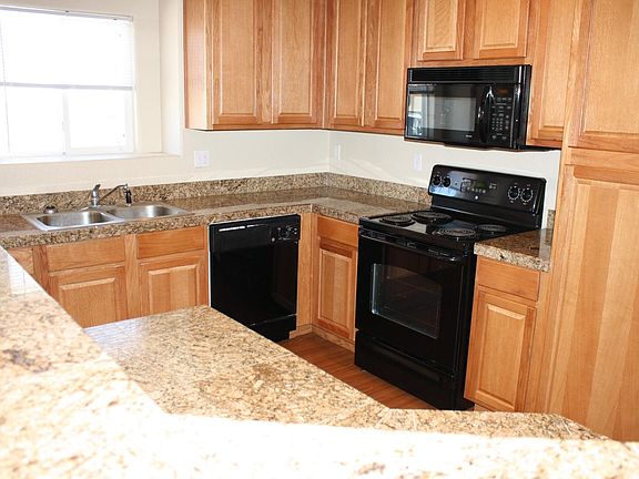 Kitchen with Granite counters and includes Refrigerator, Disposal, Microwave, Dishwasher and Stove.