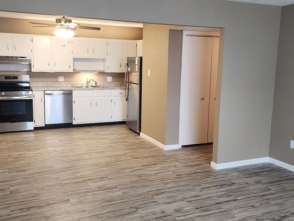 View from Living Room looking into the kitchen with a peek view of Washer and Dryer hookups located in hall closet. Apartment has newer stainless steel appliances including dishwasher and flooring.