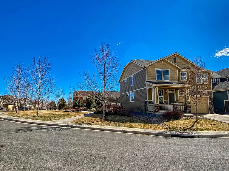 Street view with adjoining common area/park with picnic tables, neighborhood book exchange, and plenty of room for outdoor activities.