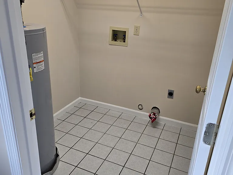 Utility room off kitchen w/ washer & dryer connections.
