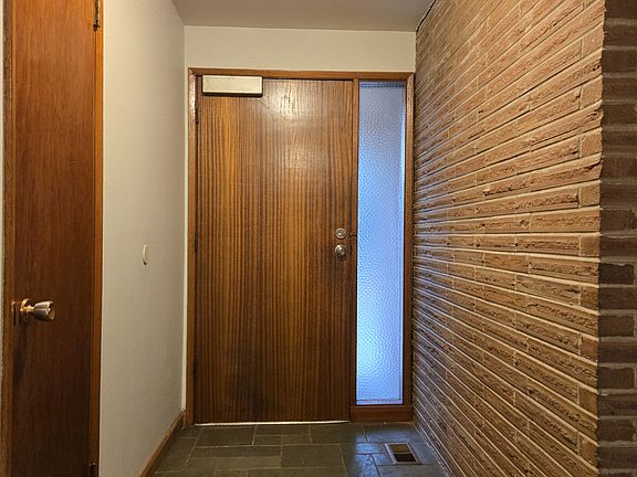 Entry way with coat closet, slate floor. Beautiful original door.