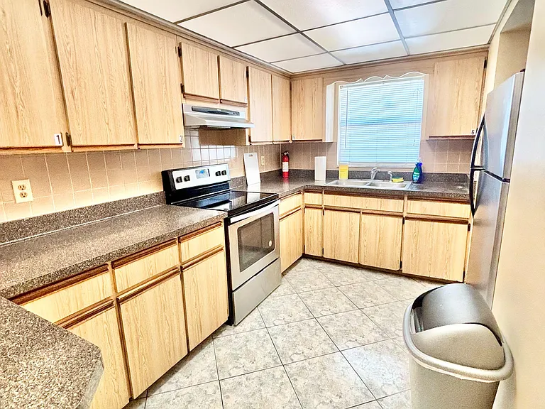 Functional kitchen with generous cabinet storage, ample counter space, and stainless steel appliances plus a double sink.