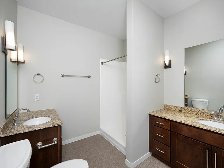 Modern bathroom with elegant granite countertops, dual sinks, and a spacious shower. Modern bathroom with elegant granite countertops, dual sinks, and a spacious shower.