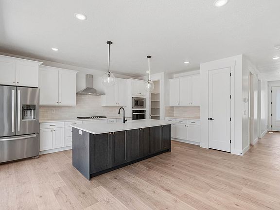 The kitchen of the Matlin has beautiful white cabinets and sprawling quartz countertops.