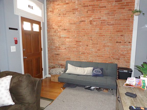 Futon in front of exposed brick