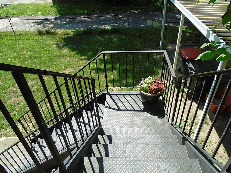 Private backdoor steps leading to large backyard.