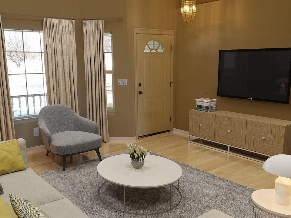 Living room with vaulted ceiling and ceiling fan. Lots of natural light front and back.