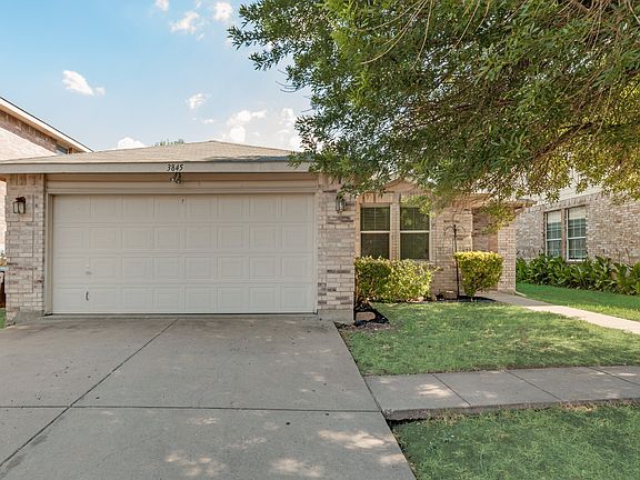 View of front of property with a garage and a front yard