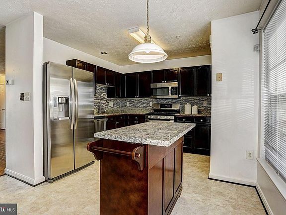 Updated kitchen with stainless steel appliances, gas stove and island.