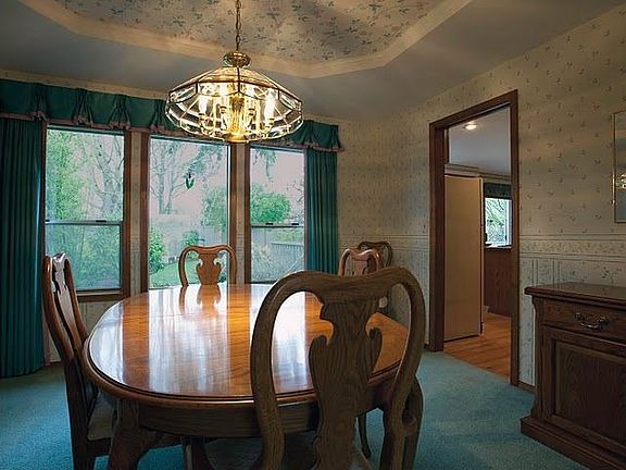 The formal dining room looks out onto the park-like backyard.