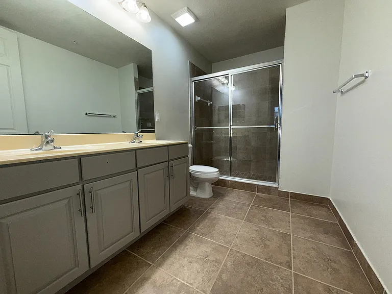Remodeled bathroom with dual sinks and walk-in shower.