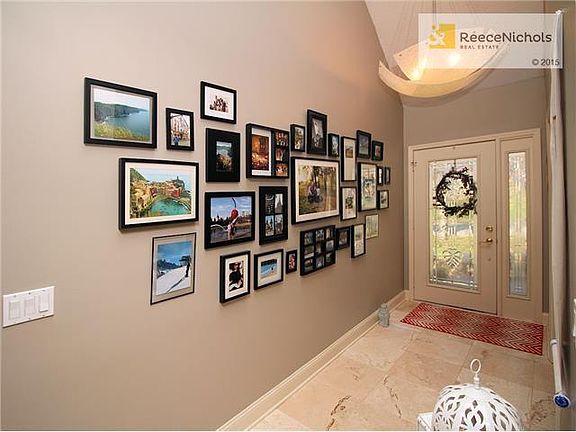 Entry hall with bright front door with side light, stone floor and impressive light fixture